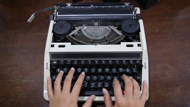 Close-up on women hand typing on type writer.