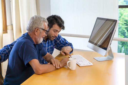 man teaching elderly man to using computer