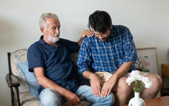 Hipster man taking care about his elderly father in house.