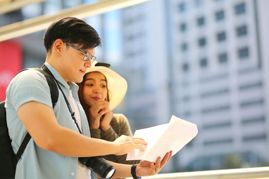 Asian couple enjoy travelling and walking on the street in city.