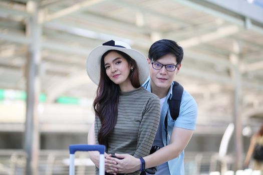 Asian couple enjoy travelling and walking on the street in city.