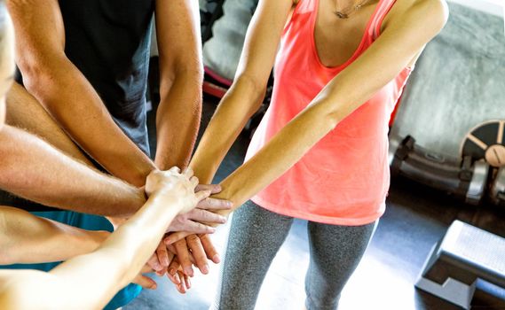 Athletic young people in sportswear doing fitness stretching exercises at fitness gym. Sport and recreation concept.