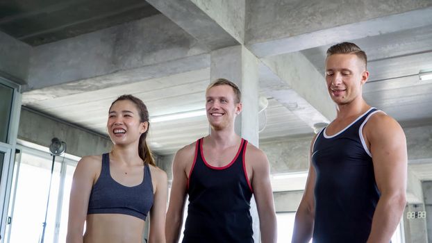 Athletic young people in sportswear doing fitness stretching exercises at fitness gym. Sport and recreation concept.