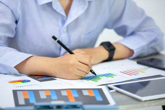 High Angle View Of Graph Papers On Table and business people writing on paperwork