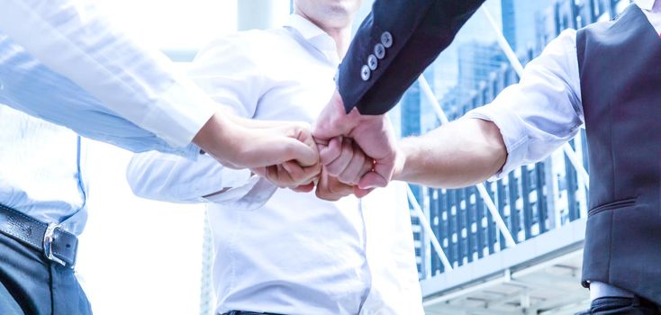 Stack of hands. Unity and teamwork concept. Close up top view of young business people putting their hands together