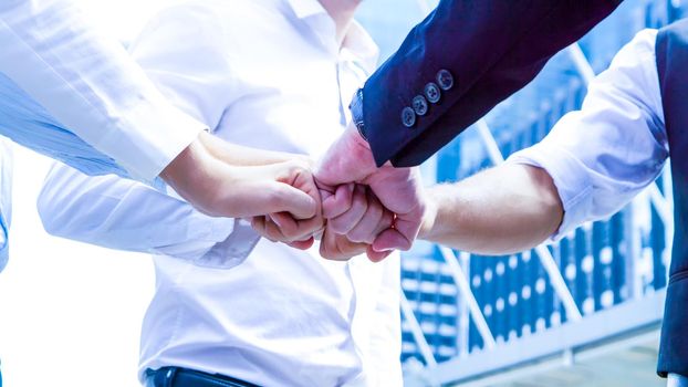 Stack of hands. Unity and teamwork concept. Close up top view of young business people putting their hands together