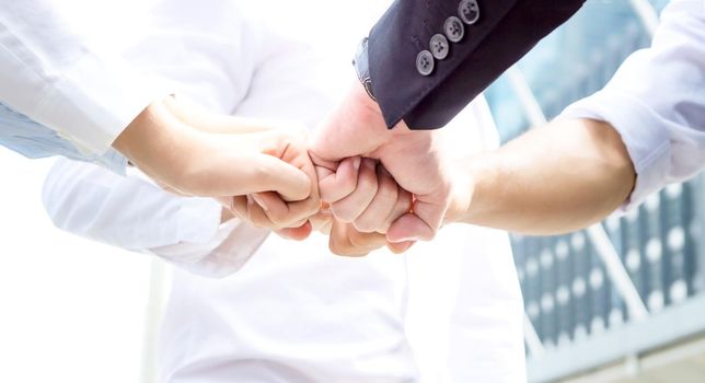 Stack of hands. Unity and teamwork concept. Close up top view of young business people putting their hands together