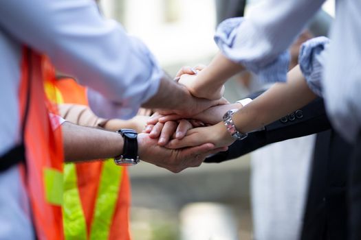 Close up low angle view of young business people putting their hands together. Stack of hands. Unity and teamwork concept.