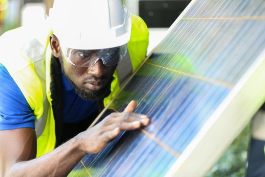 Engineer working on checking and maintenance equipment at solar panels power farm, photovoltaic cell park, green energy concept.