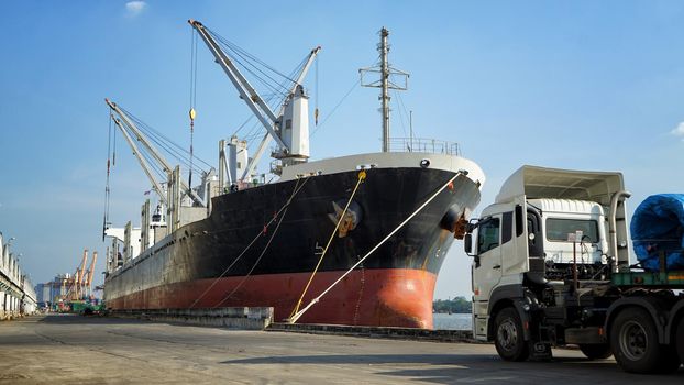 Logistics and transportation of Container Cargo ship and Cargo plane with working crane bridge in shipyard at sunrise, logistic import export and transport industry background