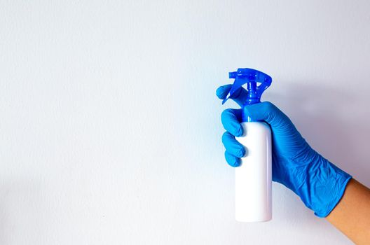 women hand with blue rubber glove and cleaning spray on white background