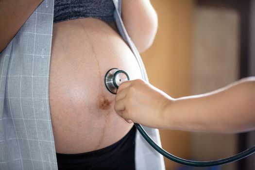 Cropped Hand of Examining Pregnant Woman Belly With Stethoscope