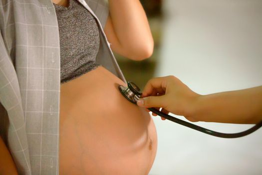 Cropped Hand of Examining Pregnant Woman Belly With Stethoscope