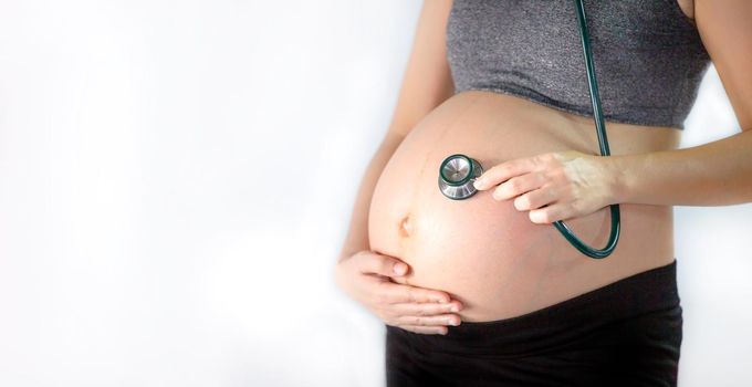 Cropped Hand of Examining Pregnant Woman Belly With Stethoscope