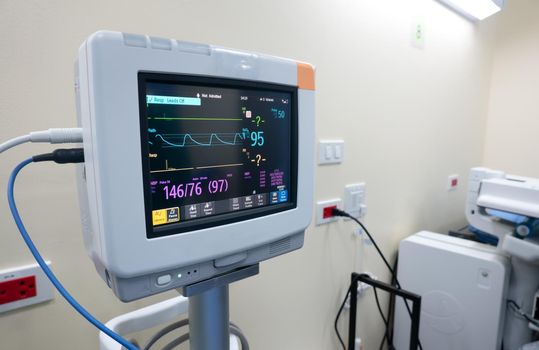 Healthcare and medical concept. Medicine doctor with stethoscope and gloves in hand and EKG Monitor 
 with pulse electrocardiogram in  hospital.