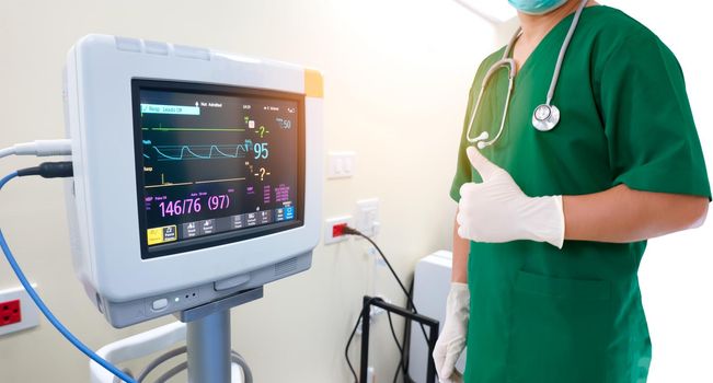 Healthcare and medical concept. Medicine doctor with stethoscope and gloves in hand and EKG Monitor 
 with pulse electrocardiogram in  hospital.