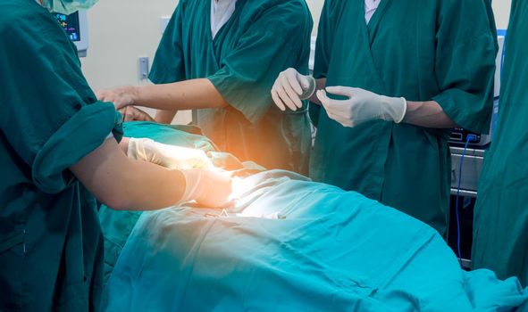 Midsection of surgery team operating Medical Team Performing Surgical Operation in Modern Operating Room
or Group of surgeons in operating room with surgery equipment.
