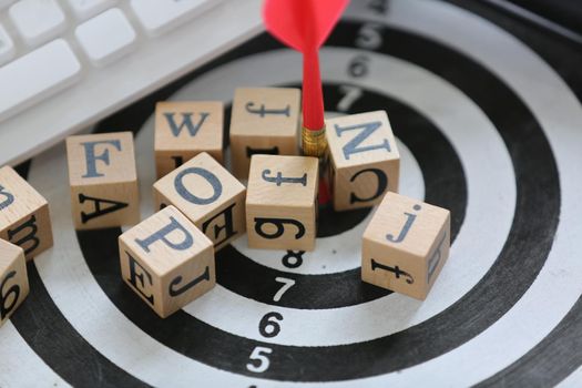 wooden cube with alphabet on target board and white keyboard 