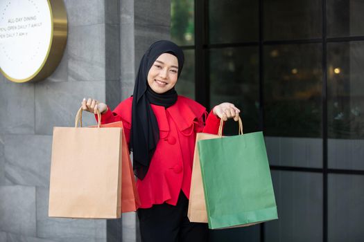 Cheerful young women holding shopping bag at outdoor.