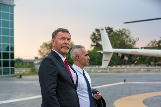 Business people traveling by helicopter , Shot of a mature businessman using a headset while traveling in a helicopter