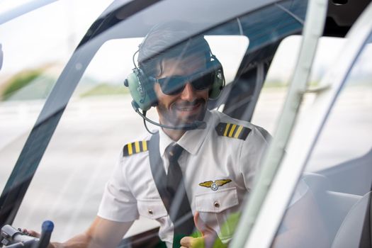 Shot of a mature Helicopter pilot using a headset while traveling in a helicopter, Business people traveling by helicopter