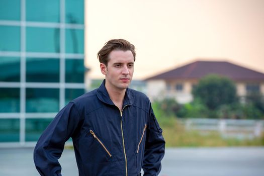 Commercial man pilot in technician suit standing in front of helicopter after check and maintenance engine	