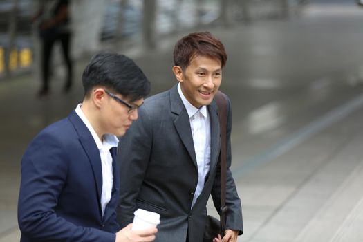 Businessman and businesswoman discussing work while walking outside office