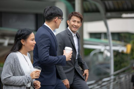 Businessman and businesswoman discussing work while walking outside office