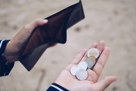 Woman holds an empty purse and coins in hand meaning money financial problem or bankrupt jobless, broke after credit card payday jobless, debt concept.