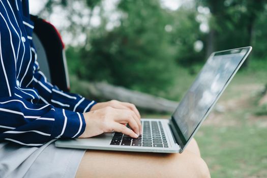 Woman using laptop and smartphone to work study in vacation cady at beach background. Business, financial, trade stock maket and social network concept.