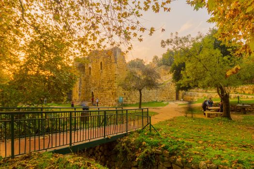 En Hemed, Israel - November 30, 2020: View of a Crusader farmhouse, with trees, fall foliage, and visitors, in En Hemed National Park (Aqua Bella), west of Jerusalem, Israel