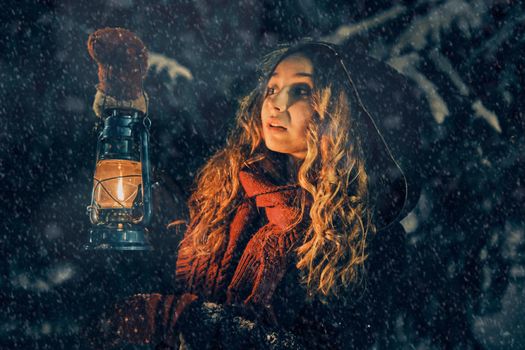 Young girl with lantern in winter forest fairy tale, book cover