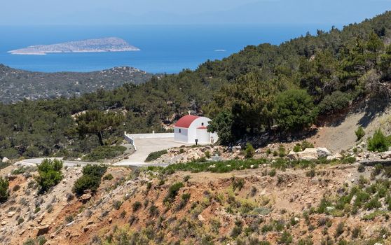 Panoramic view at landscape and coastline near Monolithos on Greek island Rhodes with church in the foreground and the aegaen sea in the background