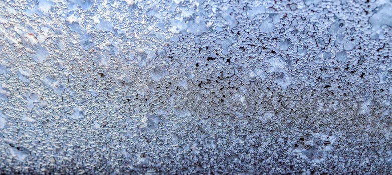 Beautiful ice flowers at a window on a cold winter day