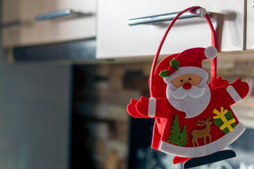 Happy santa claus hanging on kitchen furniture