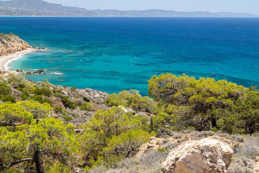 Panoramic view at beach Akra Fourni nearby Monolithos  at Rhodes island with green vegetation in the foreground and the aegean sea in the background