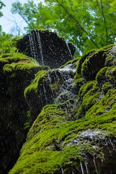 Water falling from the waterfall with a green background