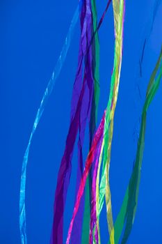 Rainbows of abstract moving lines, in vivid colors, formed by wrinkled fabrics that float lightly on a plain-colored background.