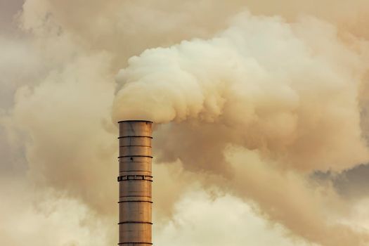 A large manufacturing facility in a regional township with steam coming from the chimney stacks during processing