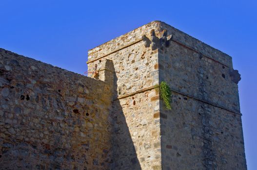 Rectangular grey tower and wall, blue sky, summer, Spain