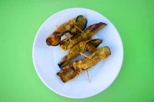 Fried eggplants rolled up with shrimps inside, in white plate, isolated