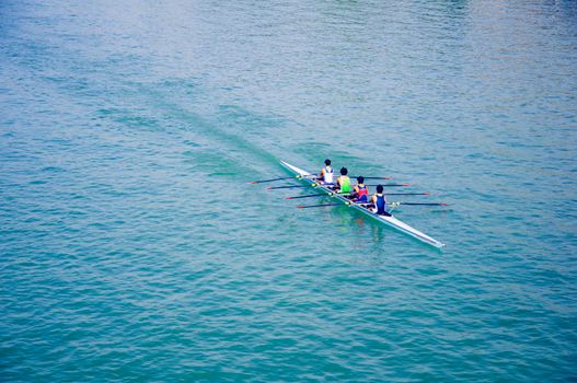 Four sportsmen on the canoe, blue river, autumn