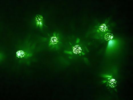 Green garland of small decorative luminous balls, night time