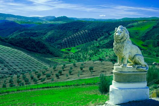 Statue of lion in the background of olive fields, Spain