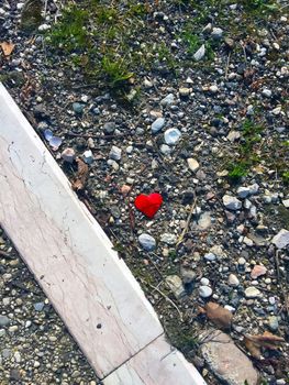 Red paper heart and stones on the ground, summer, river shore
