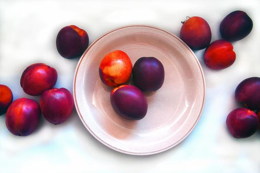 Peaches in the plate and around on the white background