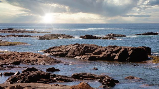 The brown Rocks and blue water of the Tasman Sea at Birubi Point near Port Stephens in regional New South Wales in Australia