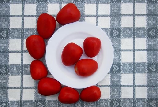 Red tomatoes out and in white plate on the table