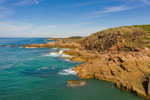 Aerial view of the brown Rocks and blue water of the Tasman Sea at Birubi Point near Port Stephens in regional New South Wales in Australia