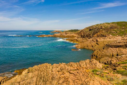 Aerial view of the brown Rocks and blue water of the Tasman Sea at Birubi Point near Port Stephens in regional New South Wales in Australia